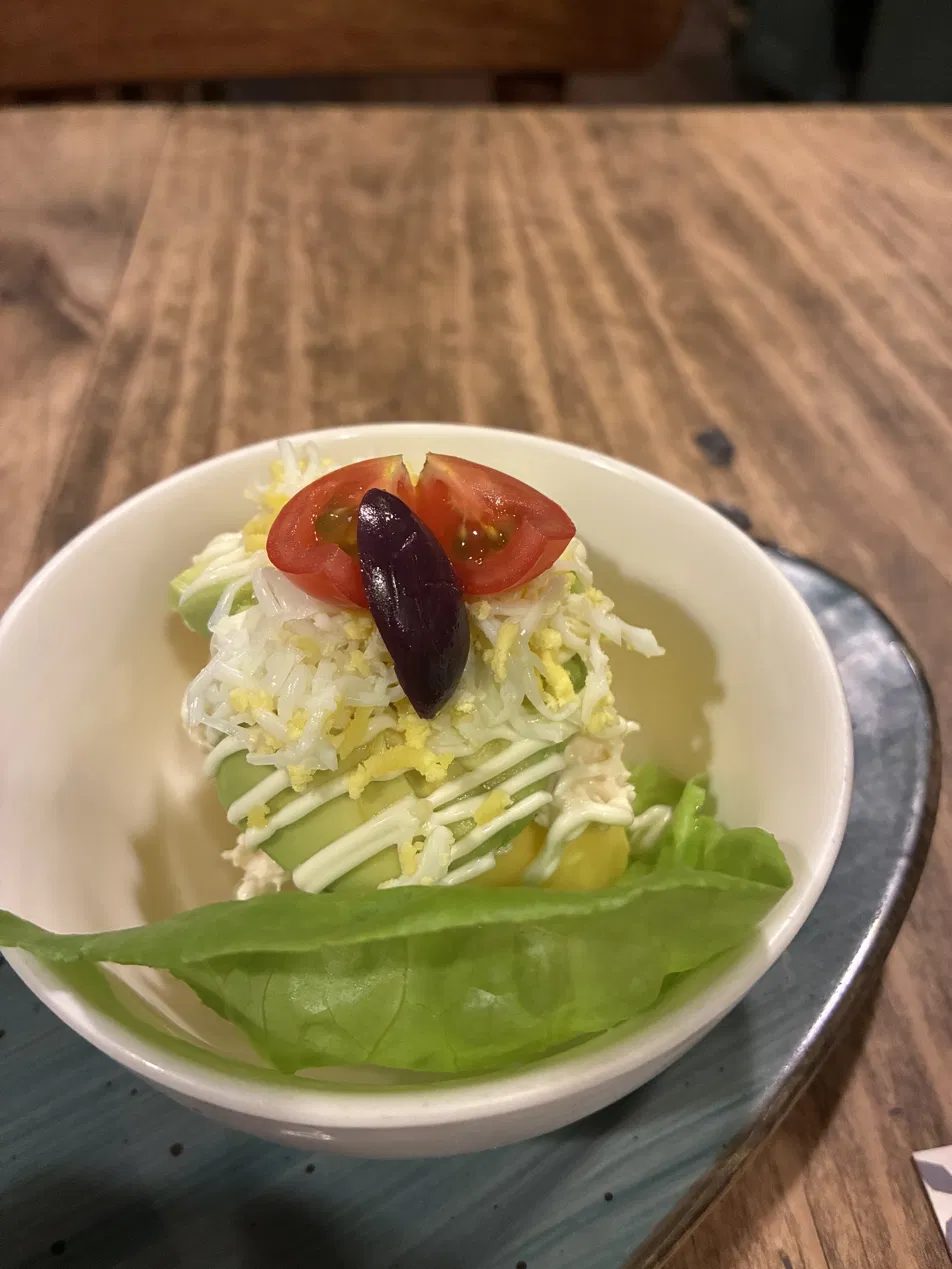 Causa topped with tomato and olive